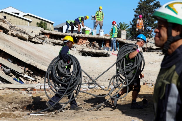 FILE PHOTO: Rescue teams work to free construction workers trapped under a collapsed building in George