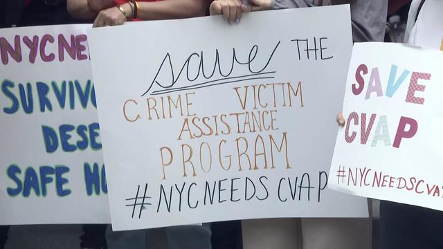 Posters at a rally reading "save the Crime Victim Assistance Program #NYCneedsCVAP" and "Save CVAP." 