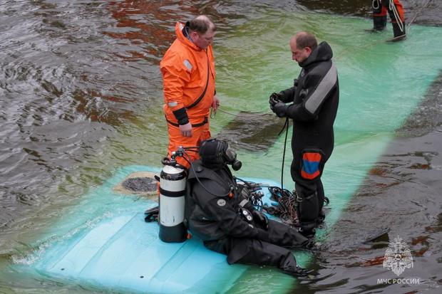 Rescue workers at the scene after a passenger bus plunged into a river in St. Petersburg, Russia, 