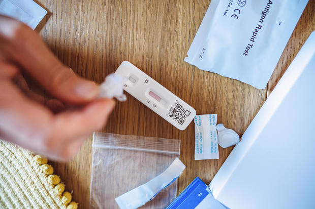 A woman using Covid-19 rapid self-test kit at home 