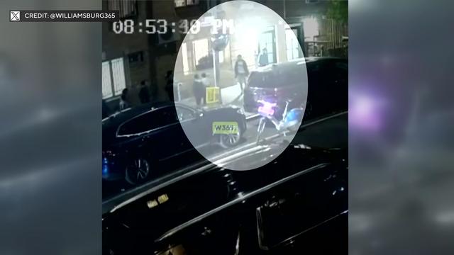 Surveillance video shows a man standing on a Brooklyn sidewalk near two children. 