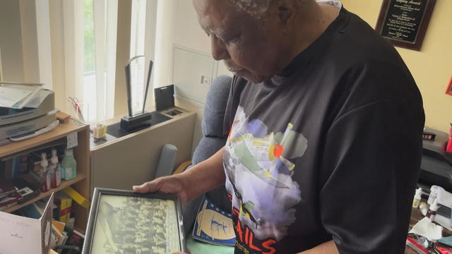 Veteran Eugene Richardson looks at a photo of a group of Tuskegee Airmen 