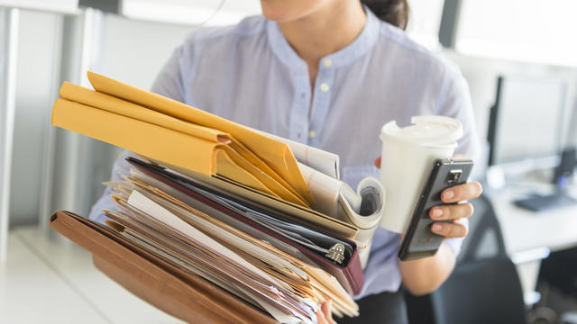 USA, New Jersey, Jersey City, Business woman holding stack of documents in office 
