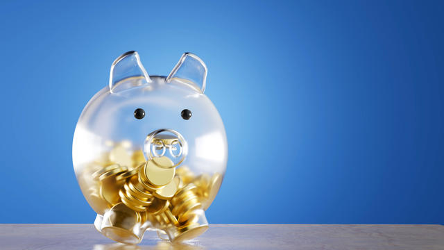 transparent glass piggy bank with gold coins on a blue background. 3d render. illustration 