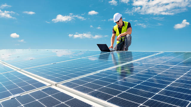 Electrician engineer working at a photovoltaic farm, checking and maintenance equipment at industry solar power 