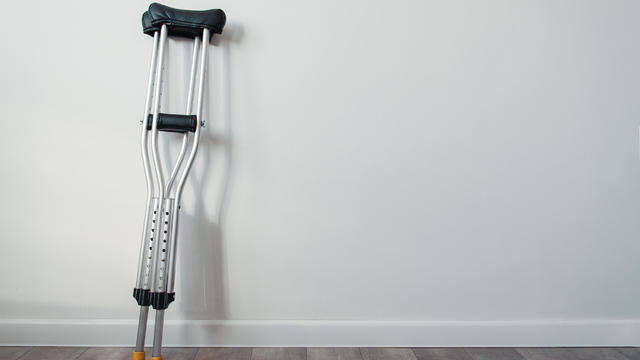 crutches stand near a white wall with copyspace 