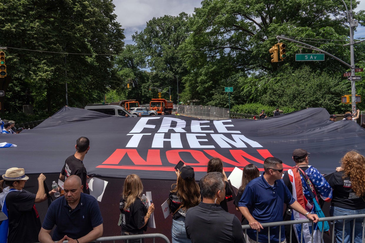 A large 'Free them now' flag is held at the Israel Day on Fifth parade on June 2, 2024 in New York City.