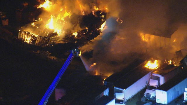 Flames are seen coming from multiple trailers and a structure during a fire in Burlington County, New Jersey 