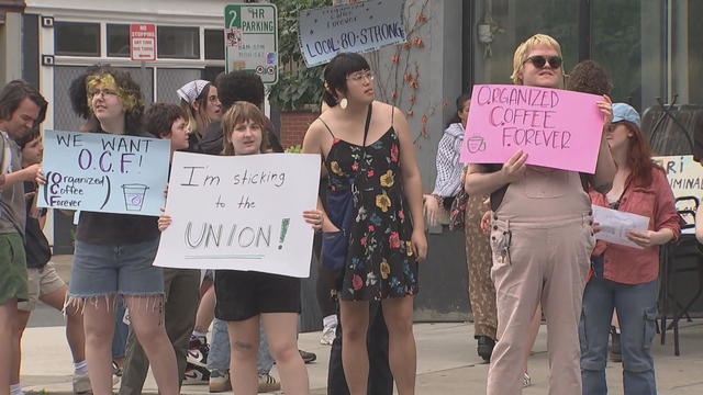 People rally with signs supporting the union outside OCF Coffee House 