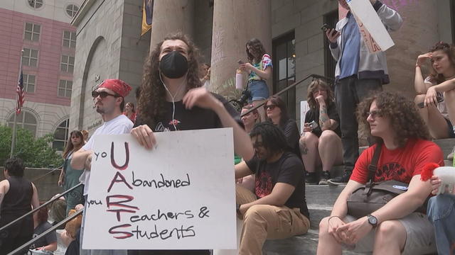 A person is seen at a rally at University of the Arts in Philadelphia holding a sign that says U abandoned your teachers and students 