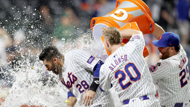 J.D. Martinez #28 of the New York Mets is doused with Gatoraby teammates Pete Alonso #20 and DJ Stewart #29 of the New York Mets after Martinez hit a walk off home run in the bottom of the ninth inning against the Miami Marlins at Citi Field on June 13, 2 