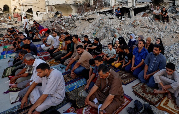 Palestinians perform Eid al-Adha prayers at the ruins of the Al-Rahma mosque destroyed by Israeli air strikes, in Khan Younis, in the south of the Gaza Strip