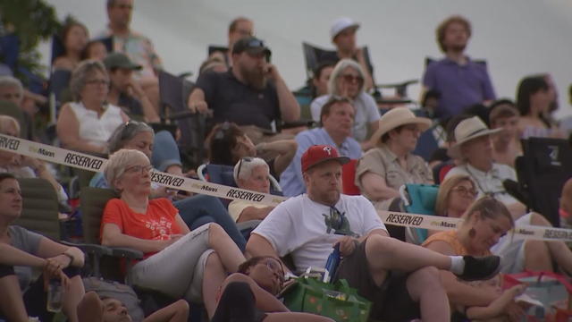 People sit in lawn chairs during a concert at the Mann Center 