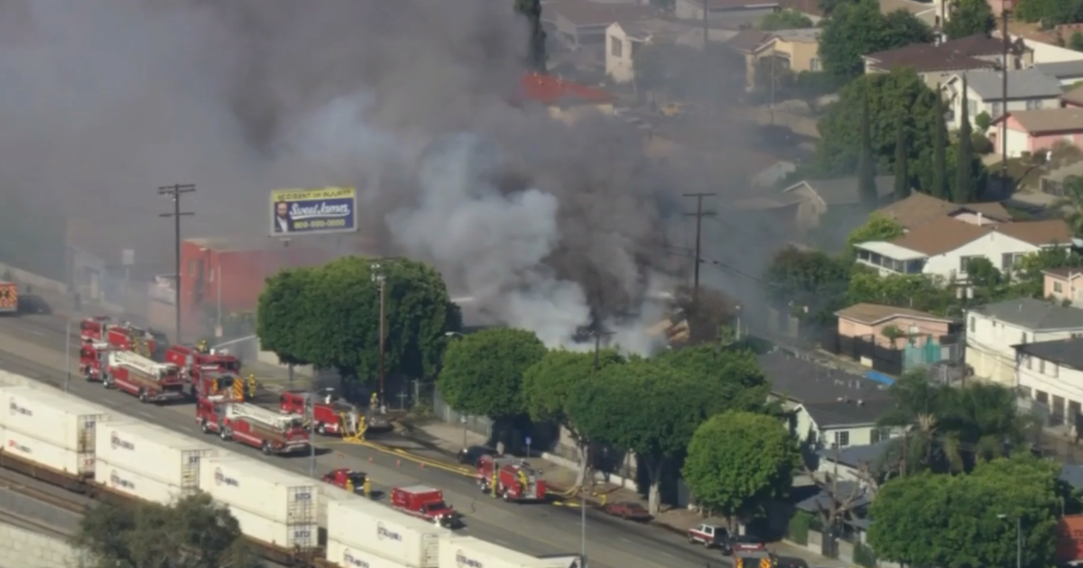 Firefighters battle the blaze at a tire shop in El Sereno