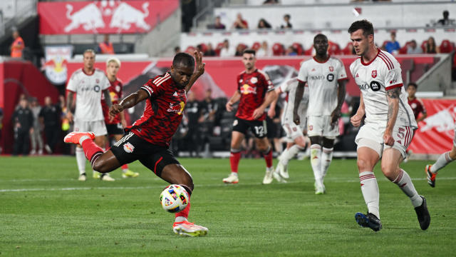 Elias Manoel #11 of the New York Red Bulls shoots as Kevin Long #5 of Toronto FC defends during the first half at Red Bull Arena on June 22, 2024 in Harrison, New Jersey. 