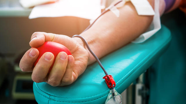 Blood donor at donation with bouncy ball holding in hand 