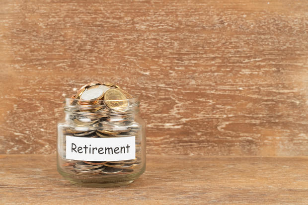 Money coin jar on wooden background retirement saving concept 