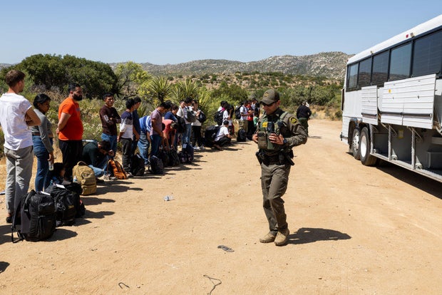 Migrants wait to be processed by the U.S. Border Patrol after crossing the U.S.-Mexico border on June 18, 2024, in Jacumba Hot Springs, California.