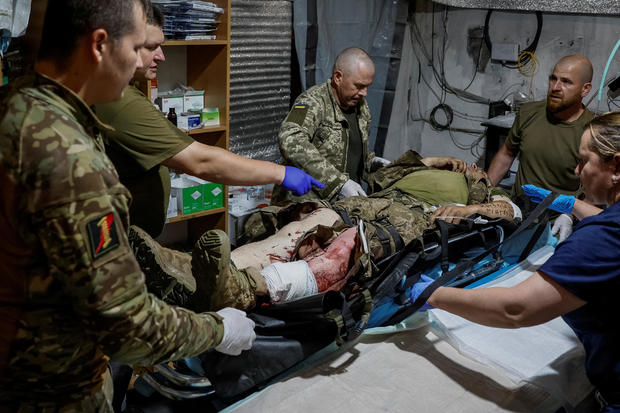 Medics help a wounded Ukrainian serviceman inside a medical stabilisation point near the town of Chasiv Yar, in Donetsk region 