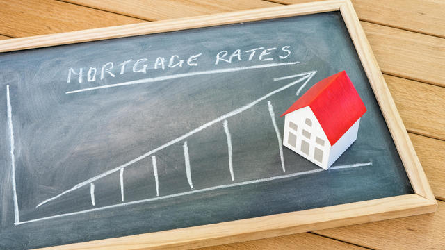 Rising mortgage rate graph on a blackboard lying on a wooden table 