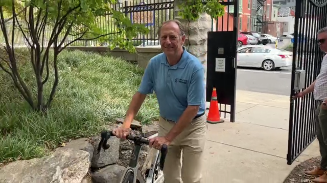 Jeff Bekos walks his bicycle through a metal gate at the Ronald McDonald House in Philadelphia 