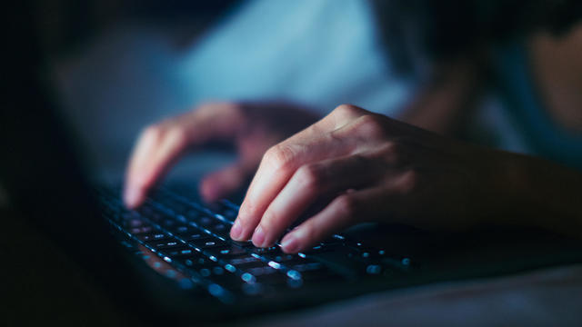 Close-up Shot Of Young Woman Working Late With Laptop In The Dark 