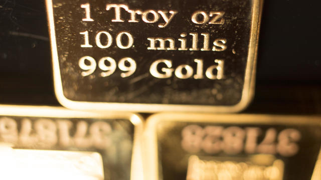 Fine solid gold 999.9 one ounce bullion ingot precious metals bar closeup isolated photo. 