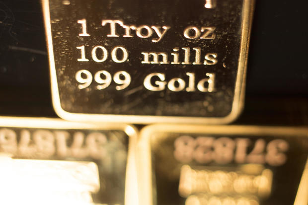 Fine solid gold 999.9 one ounce bullion ingot precious metals bar closeup isolated photo. 