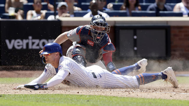 Brandon Nimmo #9 of the New York Mets beats the tag at home from Riley Adams #15 of the Washington Nationals for a run during the fifth inning at Citi Field on July 11, 2024 in New York City. 