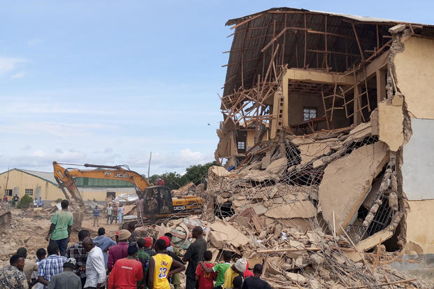 Bystanders gather next to the ruins of a school that collapsed in Jos, in central Nigeria's Plateau State, July 12, 2024