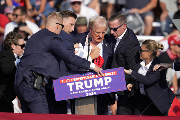 Former President Donald Trump is rushed off the stage at a campaign rally 
