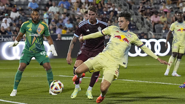 New York Red Bulls defender Noah Eile, front, pursues the ball as Colorado Rapids defender Andreas Maxsø, center, and goalkeeper Zack Steffen look on in the second half of an MLS soccer match Saturday, July 13, 2024, in Commerce City, Colo. 