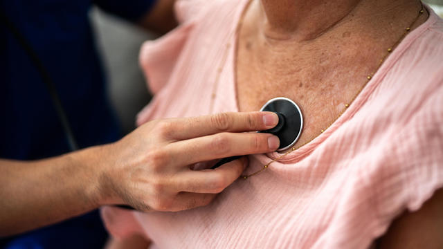 Close-up of doctor listening to a senior woman's heartbeat 