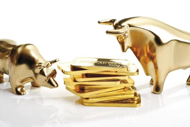 Bull and bear sculptures by gold bars 