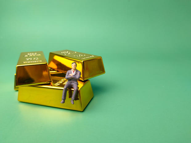 Gold bar with miniature people, Business and financial concept 