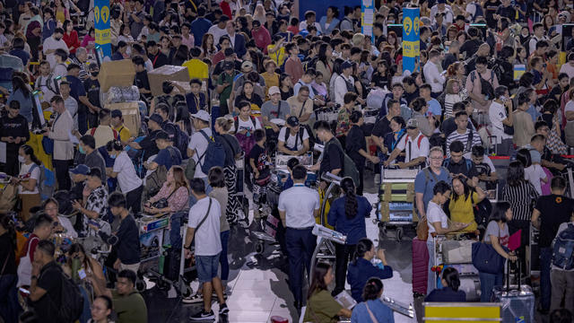 Long lines of passengers form at check-in counters at Ninoy Aquino International Airport amid a global IT disruption caused by a Microsoft outage and a CrowdStrike problem July 19, 2024, in Manila, Philippines. 