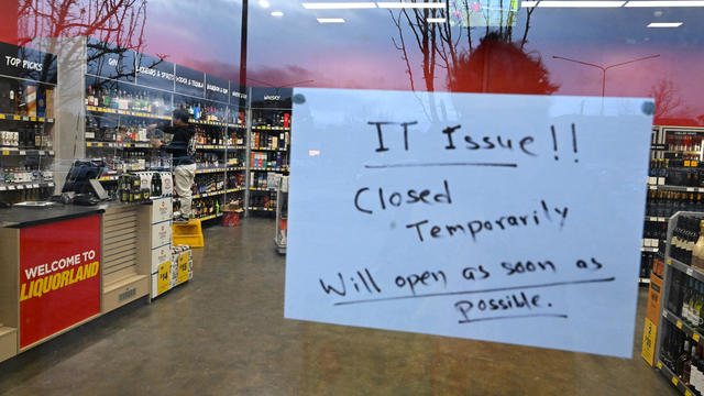 A sign notifies customers of a temporary closure due to IT issues at a Liquorland store in Canberra 