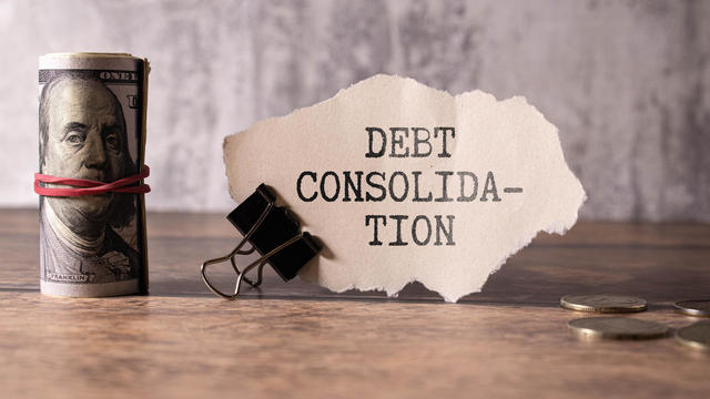 open notebook with text. glasses on the work table. words. debt consolidation 