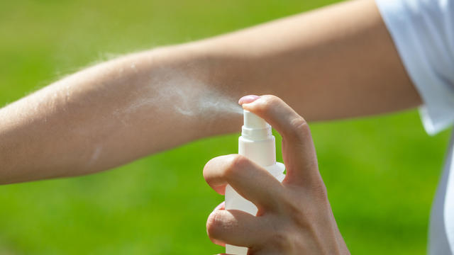 Woman spraying mosquito insect repellen 