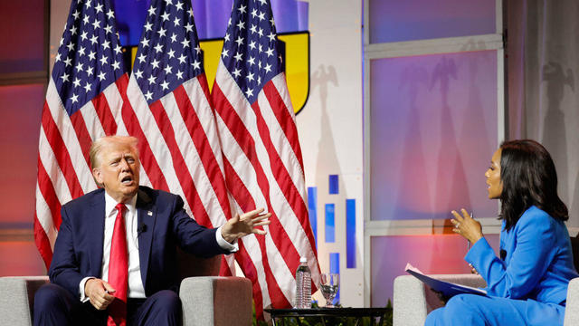 Former President Donald Trump speaks to journalist Rachel Scott on stage at the National Association of Black Journalists annual convention in Chicago 