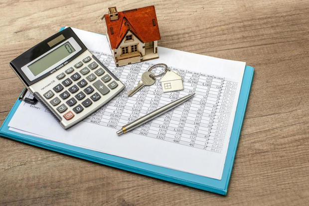 Closeup of house model and keys on wooden table 