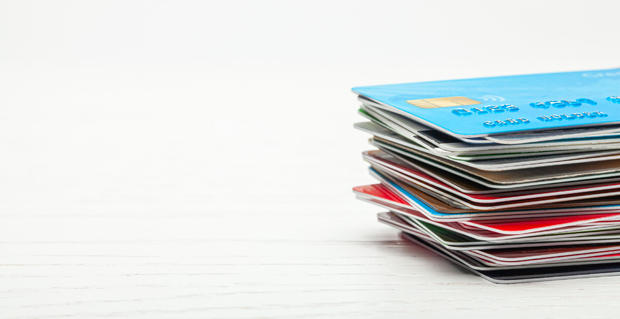 Stack of credit cards isolated on white wooden background 