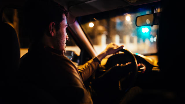 Man driving city streets at night 