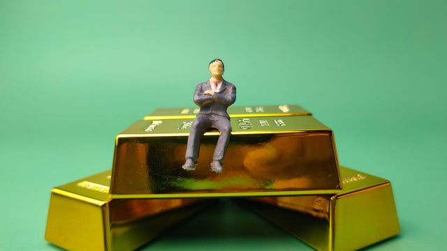 Gold bar with miniature people, Business and financial concept 