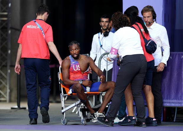 O medalhista de bronze Noah Lyles, da equipe dos EUA, é retirado da pista com uma cadeira de rodas após competir na final dos 200m masculinos nas Olimpíadas de Paris em 2024