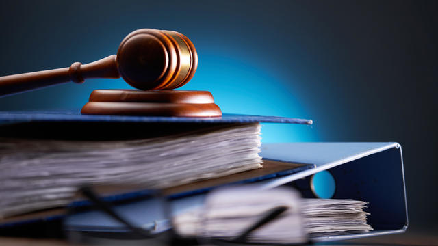 Close-up of gavel on books against black background 