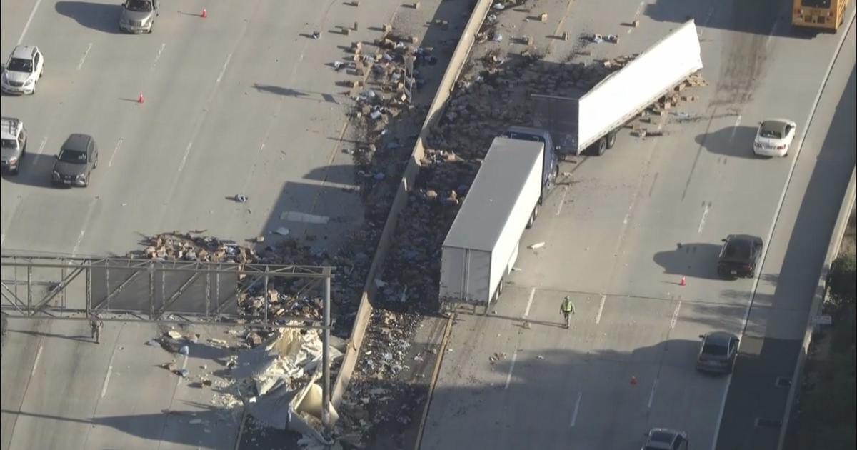 In an accident involving a semi-trailer truck, crates of raisins fly through the air on the Glendale freeway