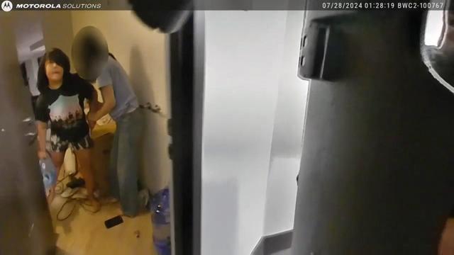 Body cam footage shows Victoria Lee holding a large water jug inside her apartment, standing next to her mother. 