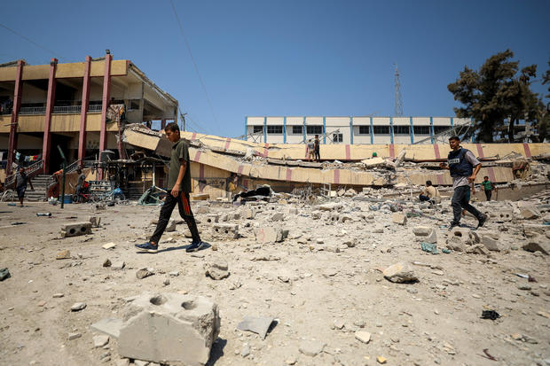 Palestinians inspect a school sheltering displaced people after it was hit by an Israeli strike, in Gaza City 