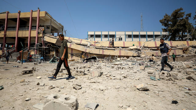 Palestinians inspect a school sheltering displaced people after it was hit by an Israeli strike, in Gaza City 